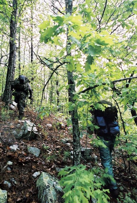 Colyer and Higgins scale a rugged mountain slope in the Ouachita Mountains as they seek out sites for camera traps. Photo: Chris Buntenbah.